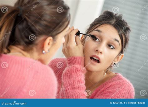 Young Brunette Woman Putting Makeup In The Mirror Stock Photo Image