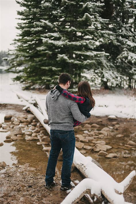 «guy Carrying Girl In Snow Covered Winter Landscape Near Lake In Banff