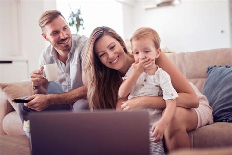 Familia caucásica feliz con portátil en el sofá Foto Premium