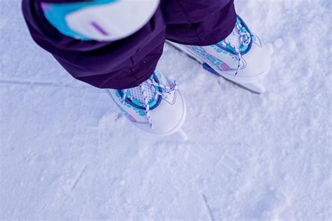 Menina roupas de inverno proteções patinando na pista de gelo