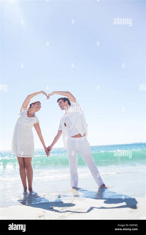 Happy couple forming heart shape with their hands Stock Photo - Alamy