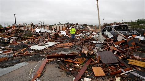 A man is surrounded by tornado damage after severe storms moved through the night before in ...