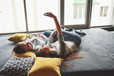 Deux Jolies Soeurs Jumelles Souriantes Tenant Un Smartphone Et Faisant