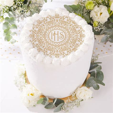 A Wedding Cake Decorated With White Flowers And Gold Monogrammed Icing