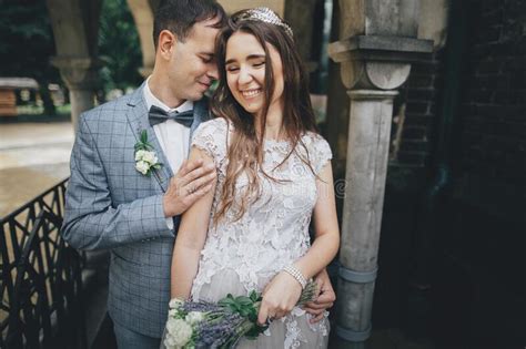 Stylish Bride And Groom Walking Under Umbrella And Kissing On