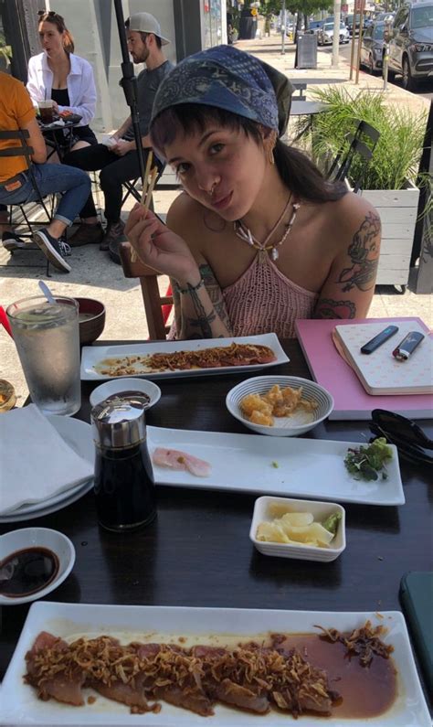 A Woman Sitting At A Table With Plates Of Food