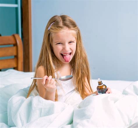 Bambina Che Tiene Una Bottiglia Dello Sciroppo Di Tosse Fotografia