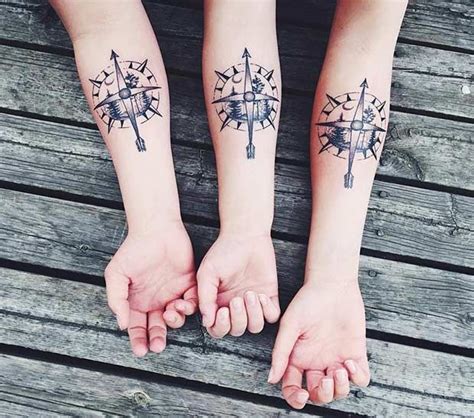 Two People With Matching Tattoos On Their Arms Holding Each Other S Hands And Looking Down At