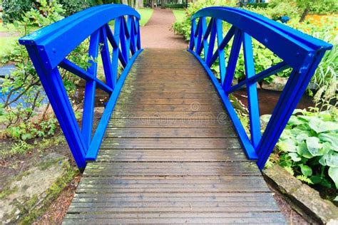 Blue Small Bridge Over River Stream Creek In Garden Nature Stock