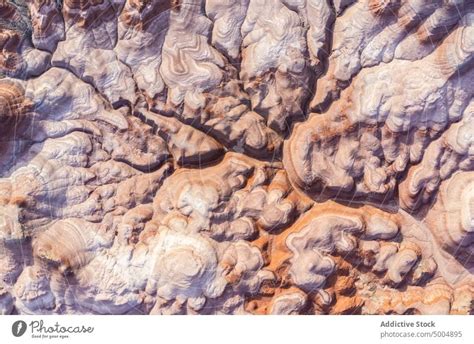 Textured Background Of Uneven Surface Of Sandstone Cliffs In Sunlight