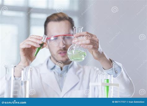 Scientist In A White Lab Coat Putting Vial With A Sample Into