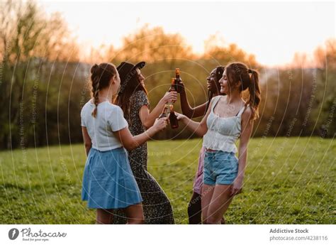 Multiracial Lesbian Couple Drinking Beer At Seaside A Royalty Free