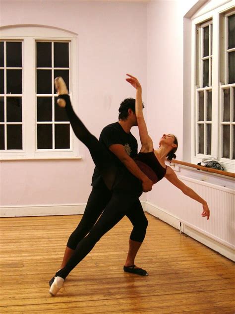 A Man And Woman Are Dancing In An Empty Room With Wooden Floors