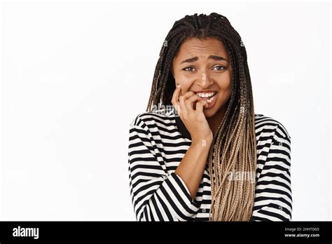 Close Up Portrait Of Scared And Anxious Black Girl Biting Finger Nails