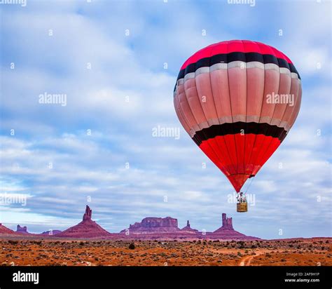 A Hot Air Balloon Flying In Front Of The Utah Monuments In The Monument