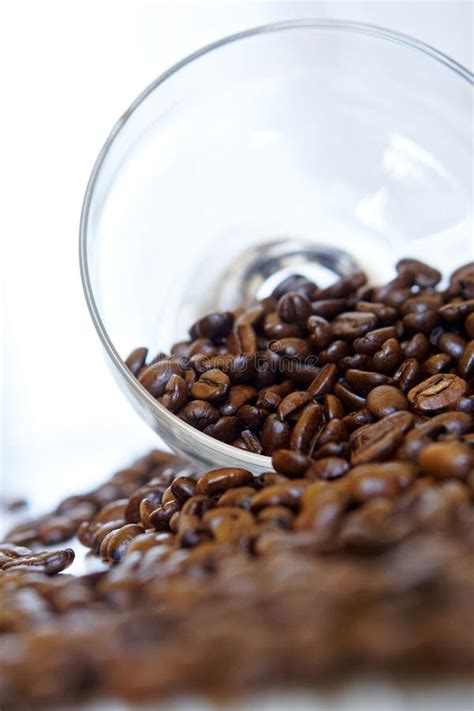 Arabica Roasted Coffee Beans Spill Out Of A Transparent Glass Bowl