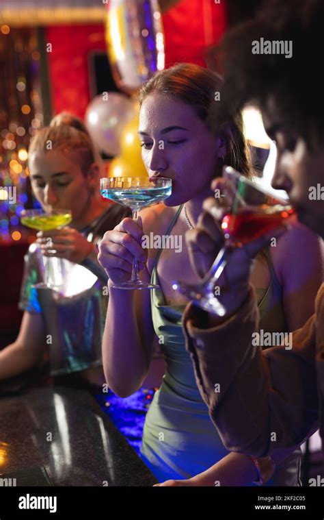 Vertical Of Three Happy Diverse Male And Female Friends Drinking