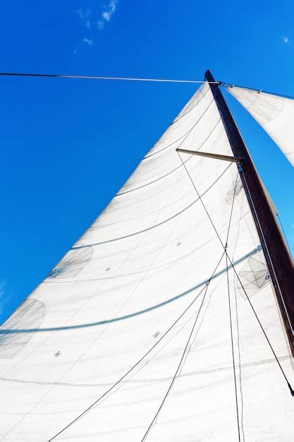 Mástil de un velero con equipo de vela bermuda contra un cielo azul