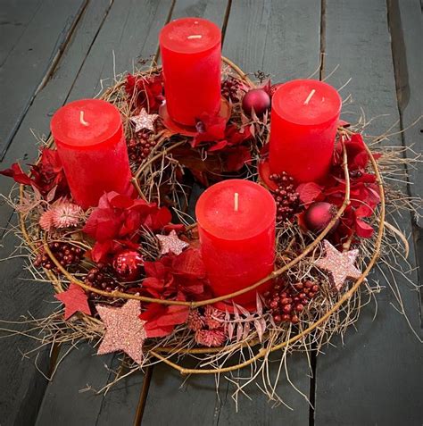 Some Red Candles Are Sitting In A Wreath