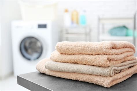 Premium Photo Stack Of Clean Towels On Table In Laundromat