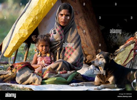 Very poor nomadic indian mother and baby outside their tent in morning ...