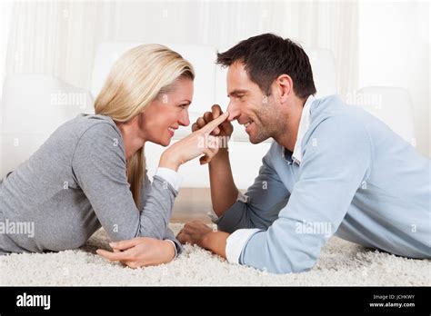 Young Couple Watching Each Other Gazing Into Each Others Eyes With Love While Lying On Their