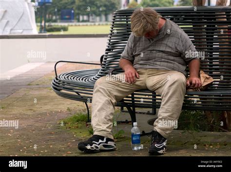 Homeless Man Sleeping On Park Bench New Orleans LA USA Stock Photo