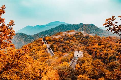 the great wall of china is surrounded by trees and mountains with ...