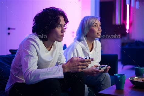 Young Cheerful Caucasian Husband And Wife Play Videogames Against Each