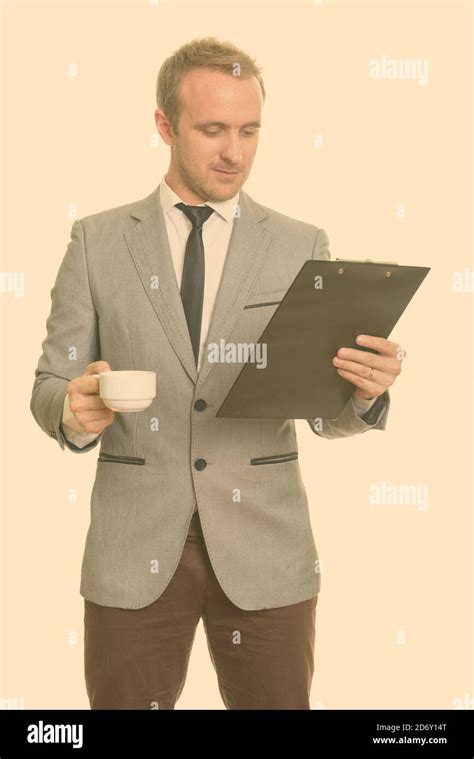 Handsome Caucasian Businessman Reading Clipboard While Drinking Coffee