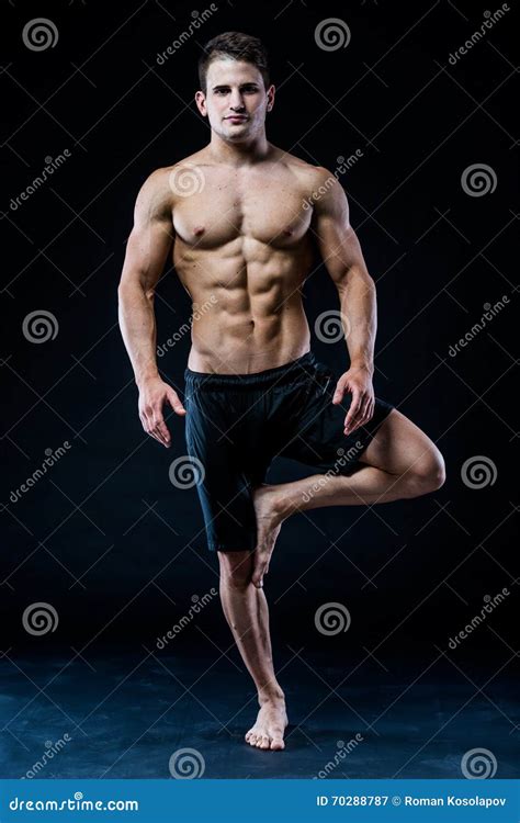 Young Strong Athlete Is Making Yoga On Black Background Stock Image