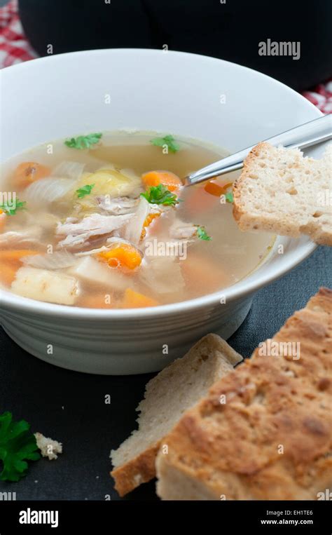 Homemade organic chicken and vegetable bouillon soup, served with bread ...