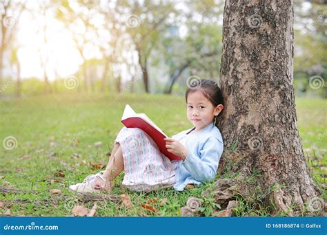 Portrait Little Asian Child Girl Reading Book In Park Outdoor Sitting