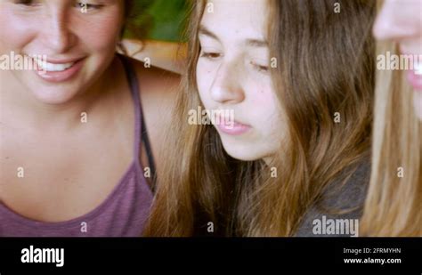 Three Beautiful Teenage Girls Sit Next To Each Other Collaborating