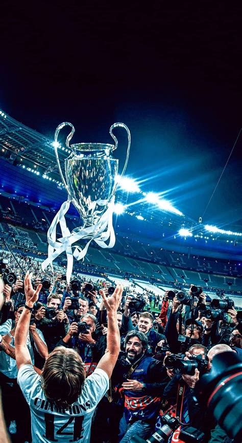 A Man Holding Up A Trophy In Front Of A Crowd At A Sporting Event