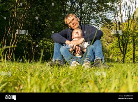 P Re Et Enfant Fils Assis Sur L Herbe Dans Le Parc En Appr Ciant Le