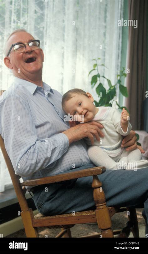 Laughing Grandpa Holding Baby In Rocking Chair Stock Photo Royalty