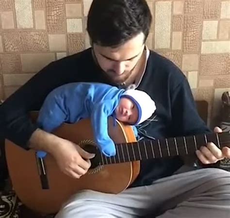 Musician Dad Plays a Jaunty Jazz Tune While His Tiny Baby is Lulled to Sleep on Top of His Guitar