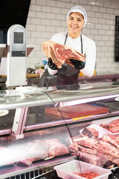 Happy Female Butcher Holding Big Chunk Of Beef Meat In Meat Section Of