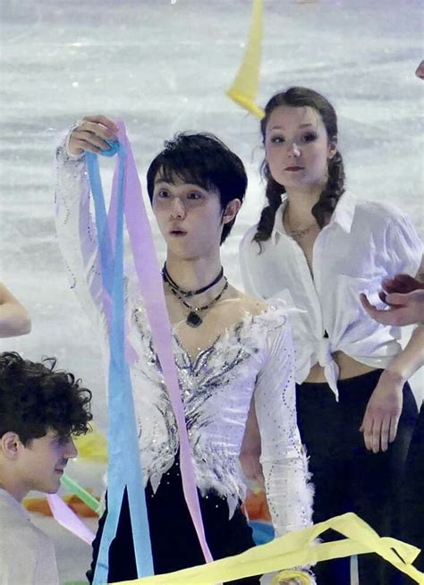 Two Women And One Man Are Holding Streamers In Front Of The Ice Skating