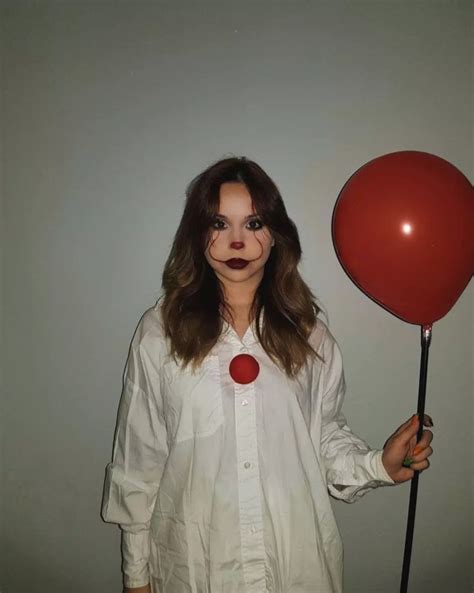 A Woman In White Shirt Holding A Red Balloon And Wearing Fake Clown