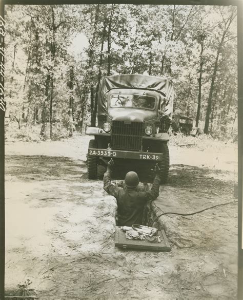 A Member Of A Quartermaster Truck Guides A Truck To A Field Grease Pit