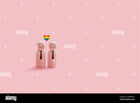 Happy Wooden Gay Couple Figures Isolated On A Pink Background Each Figure Has A Simple Smiling