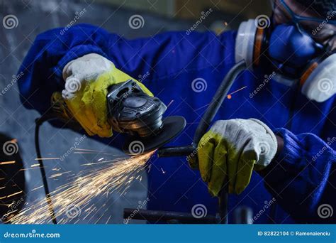 Worker Wearing Protection Equipment Using An Angle Grinder On Metal