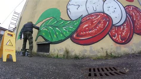 Italian artist covers racist graffiti with food murals