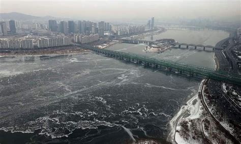 An Aerial View Of A Bridge Over Water With Buildings In The Background