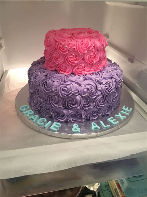 There Is A Cake With Pink And Purple Frosting On The Top Sitting In An