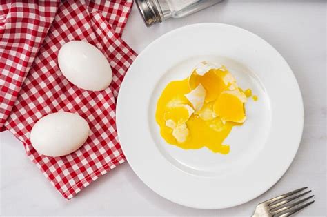 Ovo De Galinha Quebrado Em Um Prato Branco Ao Lado De Dois Ovos