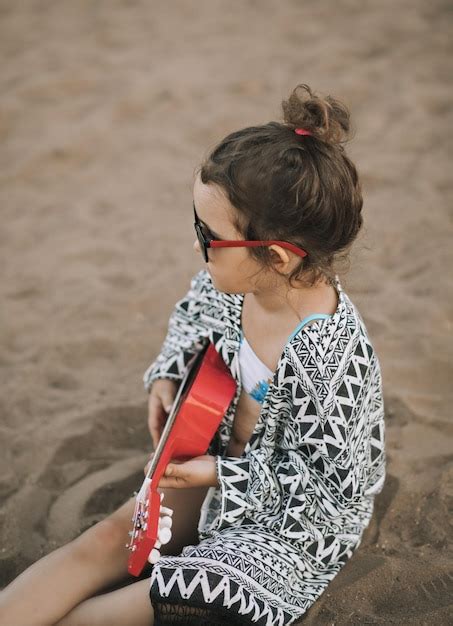 Picnic en la playa de verano graciosa y sonriente niña linda sentada en