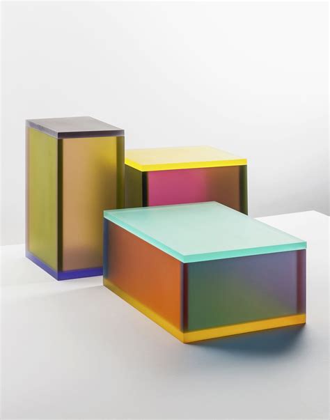 Three Different Colored Boxes Sitting Next To Each Other On A White